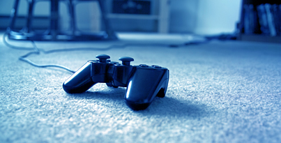 Videospielcontroler liegt auf dem Boden, bläuliches Licht